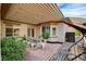 View of the covered patio, featuring a dining table, string lights, landscaping, and seating at 11342 Early Sun Ct, Las Vegas, NV 89135
