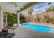 Inviting backyard swimming pool with covered patio, stylish furniture, lush landscaping, and privacy wall at 11342 Early Sun Ct, Las Vegas, NV 89135