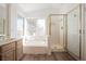 Bathroom featuring walk-in shower, soaking tub, vanity, and wood-style flooring at 124 Countrywood Cir, Las Vegas, NV 89107