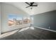 Bright bedroom with large windows, gray accent wall, carpeted floor, and a modern ceiling fan at 124 Countrywood Cir, Las Vegas, NV 89107
