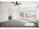 Bright bedroom features new carpet, ceiling fan, and natural light from large windows at 124 Countrywood Cir, Las Vegas, NV 89107