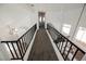 Upstairs hallway with modern black railing, carpeted floor and natural light from the large windows at 124 Countrywood Cir, Las Vegas, NV 89107