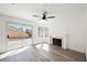 Bright living room featuring wood floors, a modern ceiling fan, fireplace, and large sliding glass doors to the patio at 124 Countrywood Cir, Las Vegas, NV 89107