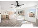 Spacious living room with a ceiling fan, leading into an eat-in kitchen with an island and lots of sunlight at 124 Countrywood Cir, Las Vegas, NV 89107