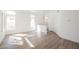 Spacious living room featuring wood floors and lots of natural light from the large windows and entry door at 124 Countrywood Cir, Las Vegas, NV 89107