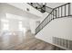 Modern staircase with black metal railing, wood floors, and lots of natural light from the large windows at 124 Countrywood Cir, Las Vegas, NV 89107