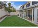 Landscaped backyard featuring an extended sunroom, patio and green lawn at 1677 Balsam Mist Ave, Las Vegas, NV 89183