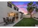 Beautiful backyard with a patio, green lawn, large palm tree, and a glass-enclosed sunroom at 1677 Balsam Mist Ave, Las Vegas, NV 89183