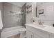 Updated bathroom features a frameless shower, new vanity, gray tile, and updated fixtures at 1677 Balsam Mist Ave, Las Vegas, NV 89183
