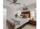 Neutral bedroom features a wood accent wall, plank flooring, a ceiling fan, and natural lighting at 1677 Balsam Mist Ave, Las Vegas, NV 89183