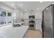 Bright kitchen features stainless steel appliances, white cabinetry, quartz countertops, and a large window at 1677 Balsam Mist Ave, Las Vegas, NV 89183