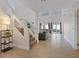 Spacious living room with wood-look floors, large windows, and a staircase at 1677 Balsam Mist Ave, Las Vegas, NV 89183