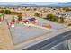 Expansive aerial view showcases the home and surrounding community with mature trees and a large gravel lot at 1800 Red Rock Dr, Pahrump, NV 89048
