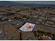 Aerial view of a property featuring a single-Gathering home with a red roof in a spacious lot surrounded by desert landscape at 1800 Red Rock Dr, Pahrump, NV 89048