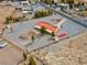 Aerial view of home and large lot with solar panels, red tile roof, mature trees, and a storage shed at 1800 Red Rock Dr, Pahrump, NV 89048