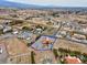 Aerial view of a property showcasing a home with a red roof, situated in a large lot amidst a desert landscape at 1800 Red Rock Dr, Pahrump, NV 89048