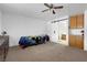 Bedroom with a ceiling fan, wooden dresser, and barn door entry to bath at 1800 Red Rock Dr, Pahrump, NV 89048