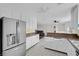 Spacious kitchen with white cabinetry, a stainless steel refrigerator, and an open view to the living room at 1800 Red Rock Dr, Pahrump, NV 89048