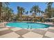 A view of a community pool surrounded by palm trees and lounge chairs at 220 E Flamingo Rd # 402, Las Vegas, NV 89169