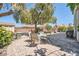 Charming backyard features a paved patio with outdoor seating beneath a large shade tree at 2288 Red Alder St, Henderson, NV 89002