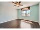 Well-lit bedroom with laminate floors, a ceiling fan, and a window overlooking the backyard at 2288 Red Alder St, Henderson, NV 89002