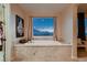 Luxurious soaking tub with stunning views, complemented by elegant decor and natural light at 261 Crimson Edge St, Henderson, NV 89012