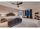Spacious bedroom features a ceiling fan, plush bed, and large windows at 261 Crimson Edge St, Henderson, NV 89012