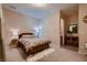 Cozy bedroom with a wood bed frame, soft lighting, and carpeted floor at 261 Crimson Edge St, Henderson, NV 89012