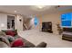 Open-concept living room with carpet flooring, large windows, and a staircase to the second floor at 261 Crimson Edge St, Henderson, NV 89012