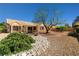 Charming backyard featuring decorative rock landscaping and mature desert vegetation at 3021 Lotus Hill Dr, Las Vegas, NV 89134