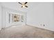 Bright bedroom with carpet and a large window providing natural light and view of landscaped yard at 3021 Lotus Hill Dr, Las Vegas, NV 89134