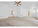Large living room with a ceiling fan, natural light, and neutral carpeting at 3021 Lotus Hill Dr, Las Vegas, NV 89134