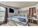 This cozy bedroom features a large bed, a mounted television, and a decorative headboard and window at 3150 Soft Breezes Dr # 2018, Las Vegas, NV 89128