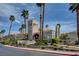 Stunning community clubhouse with manicured landscaping, complemented by towering palm trees and a blue sky backdrop at 3150 Soft Breezes Dr # 2018, Las Vegas, NV 89128