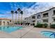 Beautiful community pool and hot tub with lounge chairs and lush landscaping on a partly cloudy day at 3150 Soft Breezes Dr # 2018, Las Vegas, NV 89128