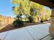 Landscaped backyard offering a serene setting with mature trees and a concrete patio at 3538 Old Course St, Las Vegas, NV 89122