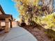 Expansive backyard showcasing mature trees, a covered patio, and a fenced perimeter for privacy at 3538 Old Course St, Las Vegas, NV 89122