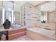 Contemporary bathroom with a soaking tub, tiled walls, and modern vanity with ample lighting at 3726 Las Vegas Blvd # 2605, Las Vegas, NV 89158