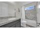 Bright bathroom featuring a single sink, granite counters, and shower with tiled walls at 3921 Jacob Lake Cir, Las Vegas, NV 89118