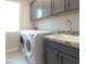 Laundry room with new side-by-side washer and dryer and a utility sink at 3921 Jacob Lake Cir, Las Vegas, NV 89118