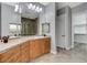 A bright bathroom offers a double vanity, tiled floors, shower stall, large mirrors, and convenient access to a walk-in closet at 4137 Cackling Goose Dr, North Las Vegas, NV 89084