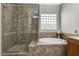 Elegant bathroom showcasing glass-enclosed shower, soaking tub, and tile accents at 4137 Cackling Goose Dr, North Las Vegas, NV 89084