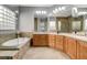 A stylish bathroom with a soaking tub, tiled floor, double vanity, and glass block window for natural light at 4137 Cackling Goose Dr, North Las Vegas, NV 89084