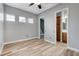 Bedroom featuring wood-look floors, neutral walls, and three windows with adjustable blinds at 4137 Cackling Goose Dr, North Las Vegas, NV 89084