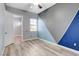 Bedroom with geometric accent wall, modern ceiling fan, and wood-look flooring at 4137 Cackling Goose Dr, North Las Vegas, NV 89084