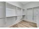 Bright walk-in closet with wood floors, white walls, and built-in shelving to maximize organization at 4137 Cackling Goose Dr, North Las Vegas, NV 89084