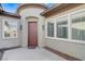 Charming front entryway with a covered porch, neutral stucco, and a red door at 4137 Cackling Goose Dr, North Las Vegas, NV 89084