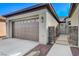 A two car garage showcasing exterior lanterns, brick accents, and drought resistant landscaping at 4137 Cackling Goose Dr, North Las Vegas, NV 89084