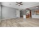 Spacious living room open to the kitchen with wood-style floors and a ceiling fan at 4137 Cackling Goose Dr, North Las Vegas, NV 89084
