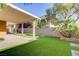 This backyard features a covered patio, lush green turf, and a beautifully landscaped area at 437 Via Stretto Ave, Henderson, NV 89011